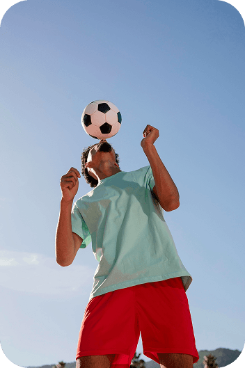 Football player balancing ball on face